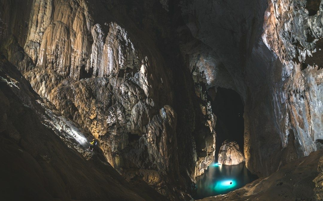 Grande grotte ornée de concrétions, avec un lac souterrain turquoise